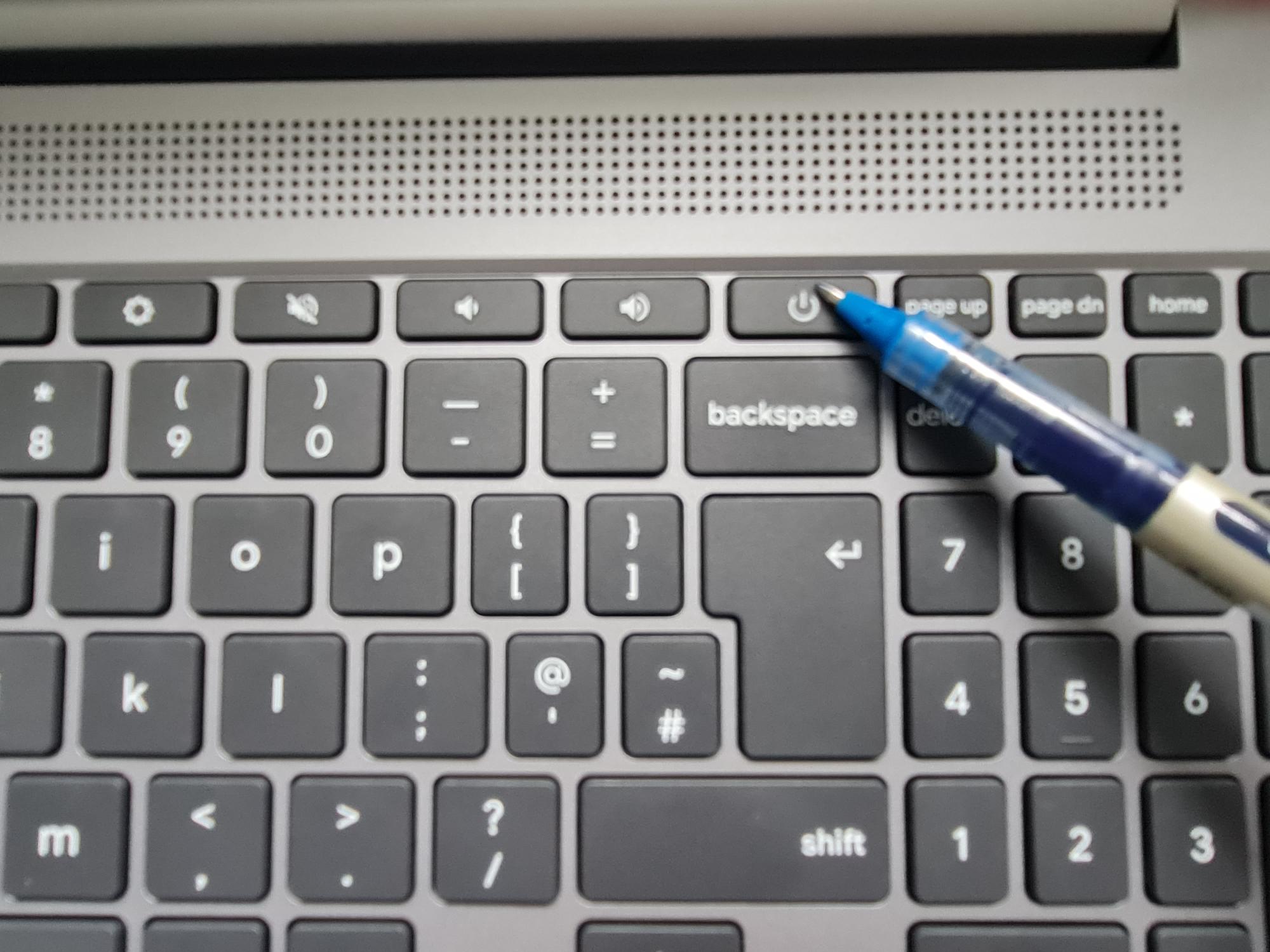 Image of a Chromebook laptop with a pen pointing the location of the power button
